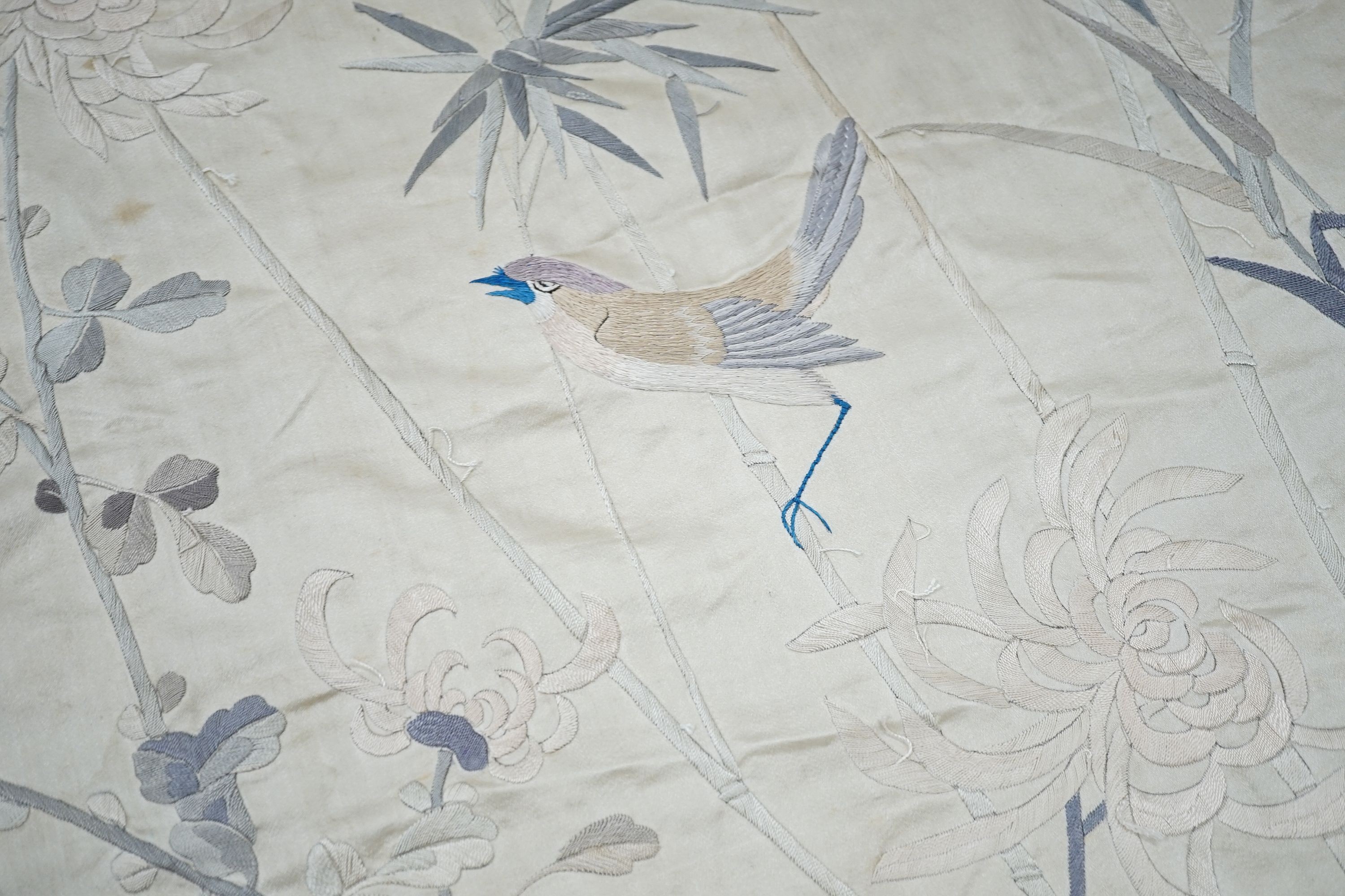 A grey silk satin Chinese embroidered panel edged with deep fringing covered with pale grey pink and beige embroidery and birds and flowers, 78 x 96cm excluding fringing